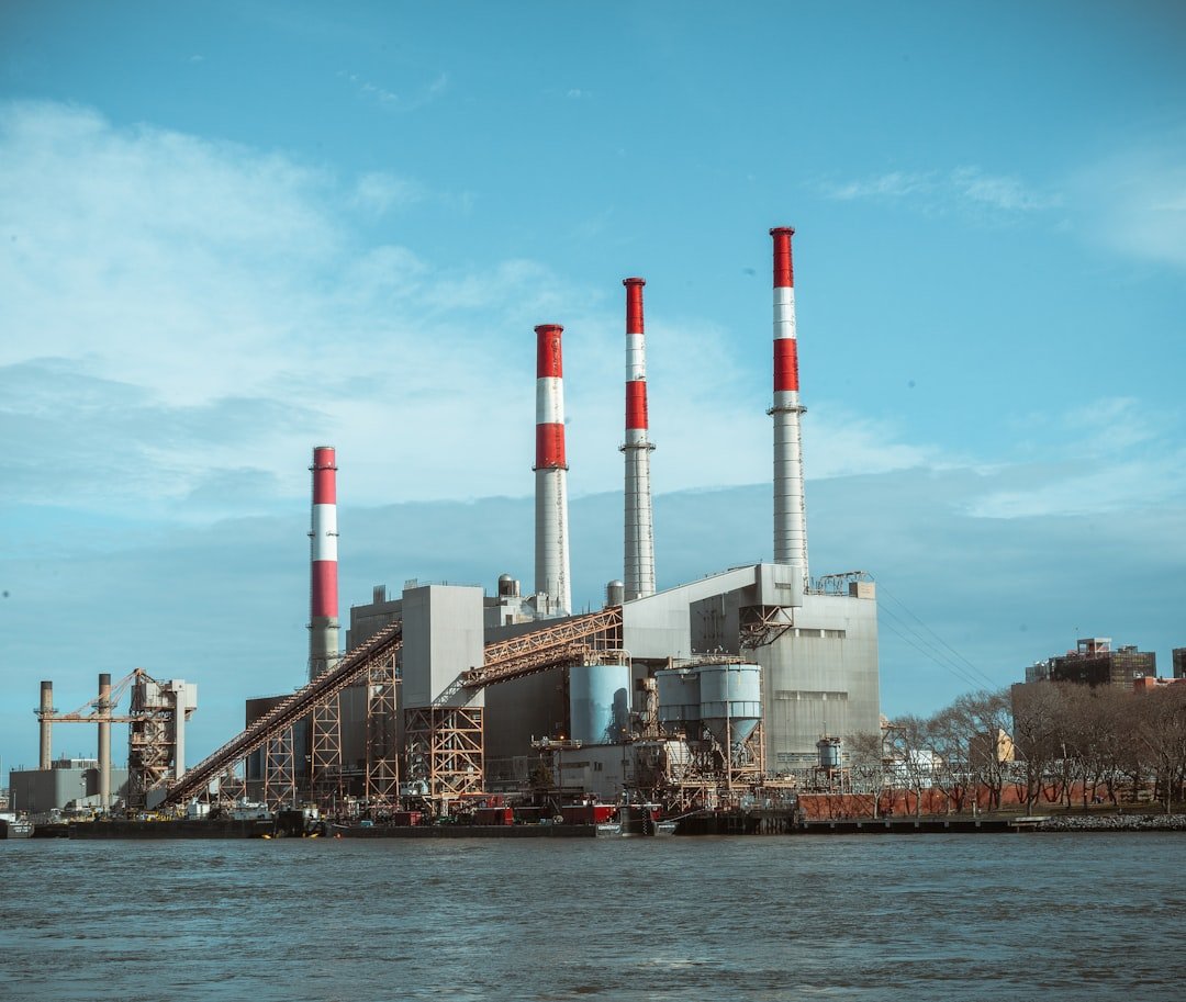 Planta industrial con chimeneas a orillas del río, símbolo de casos de productos peligrosos que defiende Bufete Ruiz y Reguant